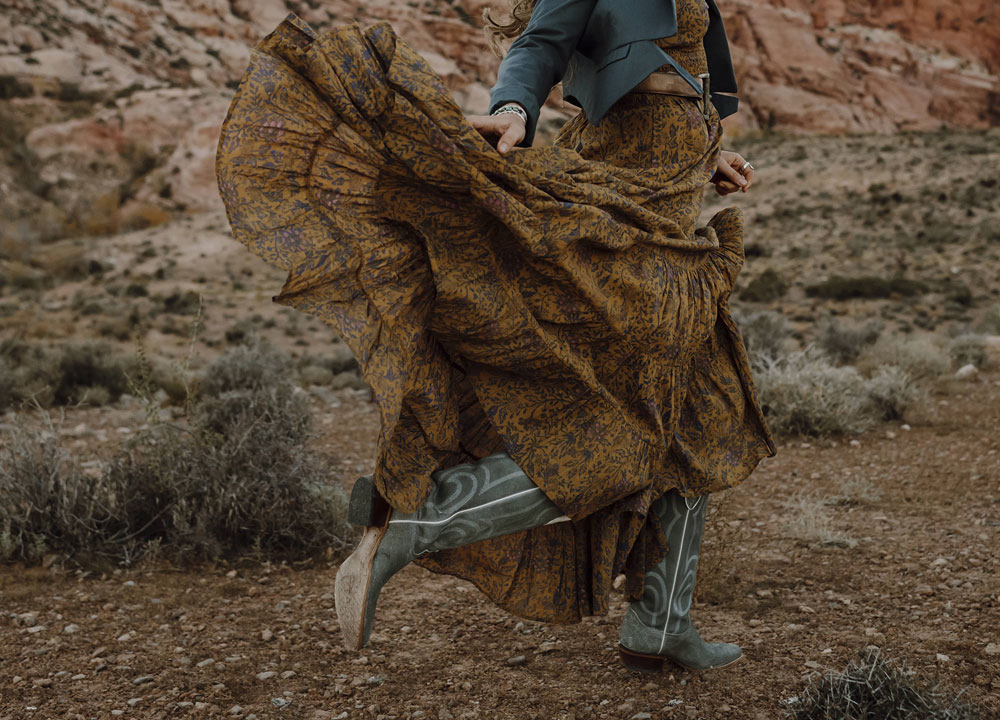 A woman wearing Justin Vintage boots dancing in the desert 
